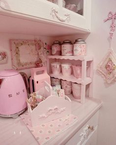 a kitchen with pink appliances and decor on the shelves