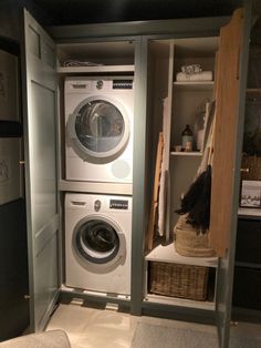 a washer and dryer in a small room next to a closet with shelves