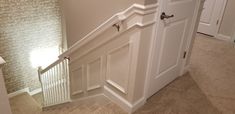 an open door leading up to a stairway in a house with carpeted flooring