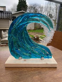 a blue glass sculpture sitting on top of a wooden table