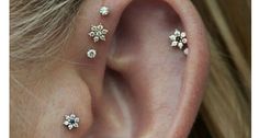 a close up of a person's ear with three piercings