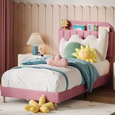 a child's bedroom with pink and white bedding, yellow stuffed animals and toys on the floor