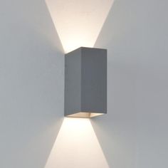 a white wall mounted light on the side of a building