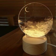 a glass ball with snow on it sitting on top of a wooden table