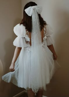 the back of a woman wearing a white wedding dress