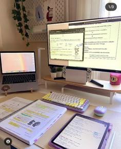 a desk with two computer monitors, a laptop and a notebook on top of it