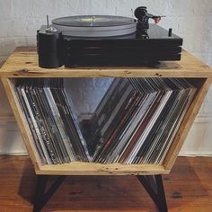 an old record player is sitting on top of a wooden shelf with vinyl records in it