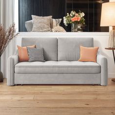 a living room with a couch, lamp and vases on the side table in front of it