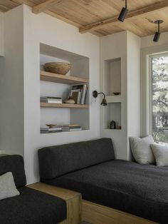 a living room filled with furniture next to a window and bookshelf on the wall