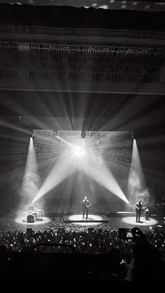 the stage is lit up with spotlights and people are standing in front of it