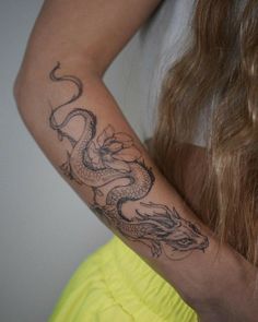 a woman with a dragon tattoo on her arm