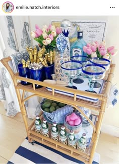 a wicker serving cart filled with food on top of a wooden floor next to a blue and white rug