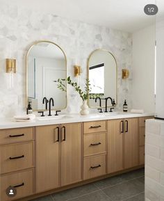 a bathroom with two sinks and mirrors on the wall