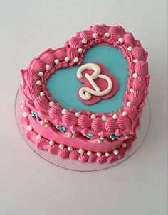 a heart shaped cake with the letter s on it's side and decorative icing