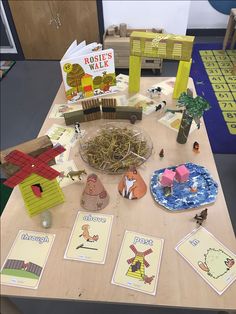 a wooden table topped with lots of cards and toys