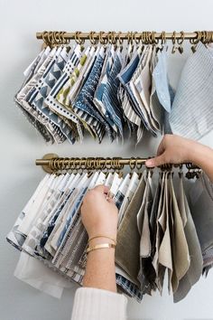 a person is holding folded clothes on a rack