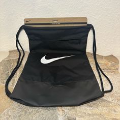 This Nike Brasilia Drawstring Bag Is A Must-Have For Any Sports Enthusiast. With A Black And White Color Scheme And Solid Pattern, It's A Stylish Accessory For Any Outfit. The Bag Is Made Of Polyester And Features Adjustable Straps And Pockets For Convenient Storage. Measuring 14" In Width, 20" In Height, And 10.5" In Depth, It's The Perfect Size For All Your Essentials. The Drawstring Closure Allows For Easy Access To Your Belongings And The Nike Branding Adds An Extra Touch Of Style. Made In I Nike Drawstring Bag, Black Bucket Bag With Removable Pouch For Daily Use, Black Bucket Bag With Removable Pouch For Travel, Travel Bucket Bag With Removable Pouch In Black, Black Travel Bucket Shoulder Bag, Travel Black Bucket Bag With Removable Pouch, Black Bag With Adjustable Strap For Daily Use, Black Crossbody Bag For Daily Use, Functional Black Shoulder Bag For Shopping