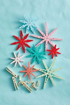 five small wooden stars on a blue background, one is red and the other is green