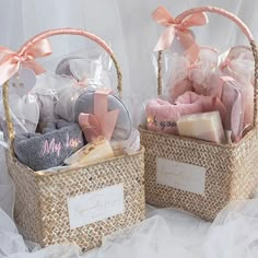 two baskets filled with baby items sitting on top of a white sheet covered floor next to each other