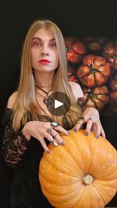 a woman holding a giant pumpkin in her hands