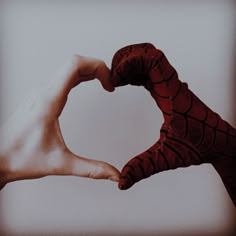 two hands in the shape of a heart with one hand holding another's arm