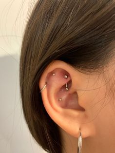 a woman's ear with two piercings attached to the side of her ear