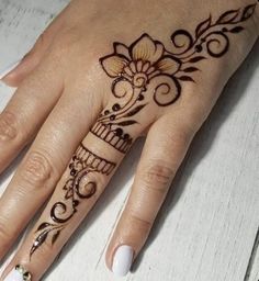 a woman's hand is decorated with hennap and flower designs on it