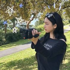 a young woman holding up a camera to take a picture with stars in the background