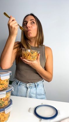 a woman eating cereal out of a bowl with a spoon in front of her face