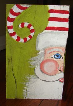 a painting of santa claus with candy canes on his nose and green background, sitting on a wooden floor