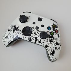 a close up of a controller with cats painted on the front and back side of it