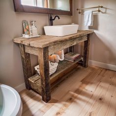 a bathroom with a sink, mirror and towel rack in front of the vanity is made out of wooden planks