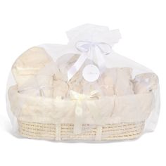 a white basket filled with baby items on top of a white table next to a ribbon