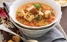 a bowl of soup with tofu and carrots in it on top of a table