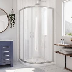 a white bathroom with a corner shower stall and blue cabinetry on the side wall