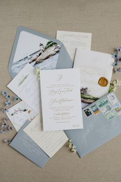 the wedding stationery is laid out on top of each other, including envelopes and cards