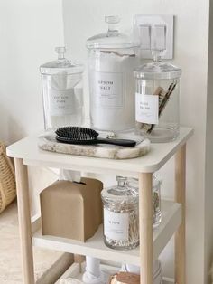 a white table topped with lots of bottles and containers on top of it's shelf