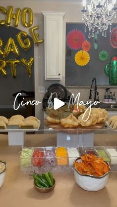 a table filled with lots of food on top of a counter next to a chandelier