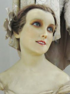 a woman's head is shown in front of a mannequin wearing a dress