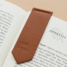 an open book with a leather tie laying on top of it