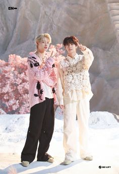 two young men standing next to each other in the snow