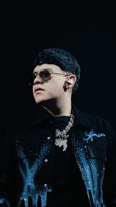 a man in black shirt and sunglasses on stage