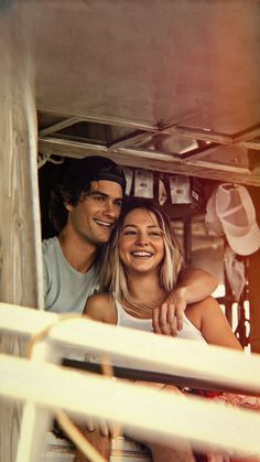 a man and woman sitting in the back of a truck