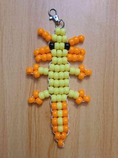 an orange and yellow beaded key chain with a black eye on it's face