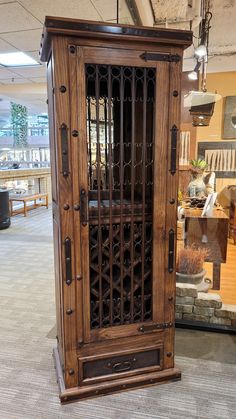 an ornate wooden cabinet in the middle of a room with tables and chairs behind it