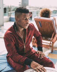 a man sitting on top of a wooden chair