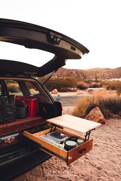 the back end of a car with its trunk open and food in it's drawer