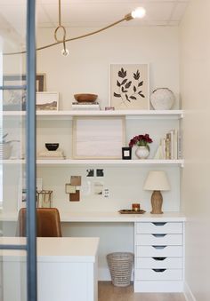 a white desk and shelves in a room