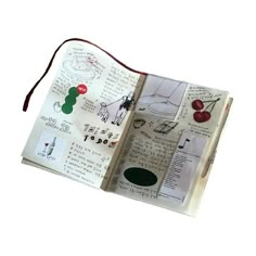 an open book with drawings and writing on the pages, including a red string attached to it