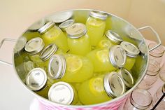 a bucket filled with lemonade sitting on top of a table